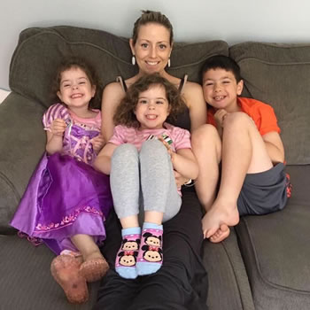Tina Klugman sitting on couch with her 3 young children