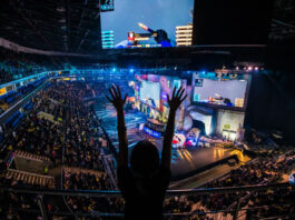 excited fan standing up cheering in an esports stadium