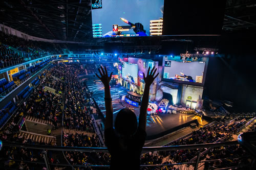 excited fan standing up cheering in an esports stadium
