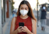 How COVID-19 has Changed Social Networks and Online Engagement girl with mask looking at cellphone and walking