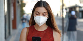 How COVID-19 has Changed Social Networks and Online Engagement girl with mask looking at cellphone and walking