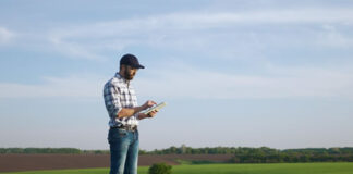 I’d Rather Drive – Building a Tech Company in Flyover Country farmer using technology tablet in a large field