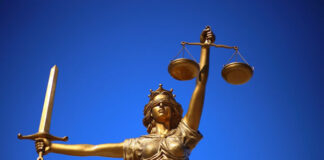 bronze statue of Lady Justice with blue sky background