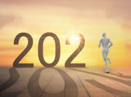 year 2021 with robot running towards sunset horizon