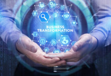 man clasping hands together and holding a hologram globe that shows business transformation