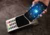 Cloud-Based POS Tech Changing the Specialty Retail Industry Amid COVID woman holding cellphone next to POS credit card machine