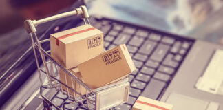 miniature shopping cart and boxes sitting on laptop keyboard