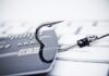 Most Common Forms of Cybercrime a credit card that has a fish hook stuck through it
