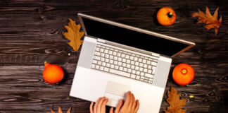 Surviving A COVID Thanksgiving top view of girl typing on laptop with autumn leaves and pumpkins around