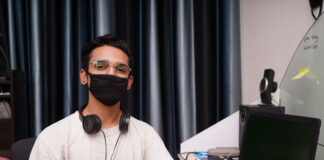 developer at work desk with mask on looking at camera