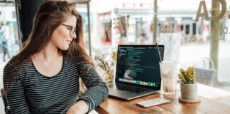 Strategy to Successfully Launching an App in 2021 girl developer writing code on her laptop at a coffee shop