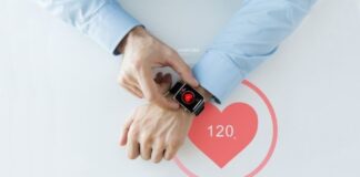 Helpful Tips for Designing Medical Devices top view of man checking his smart watch on his wrist with heart icon on the face