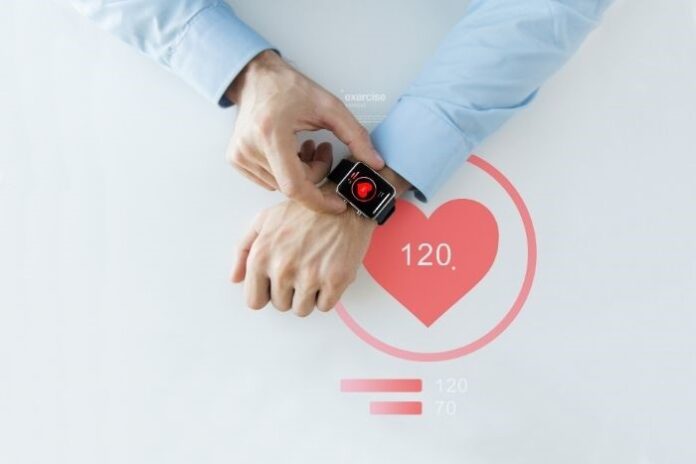 top view of man checking his smart watch on his wrist with heart icon on the face
