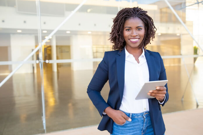 black women business leader holding ipad and smiling into camera