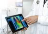 physician holding a tablet displaying a 2d radiology image