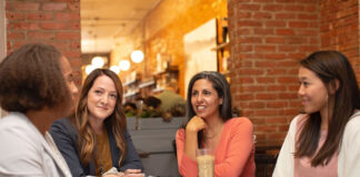 6 Ideas to Invest and Empower Women Through Technology business women in a discussion at a table to empower women through technology