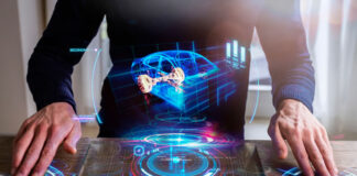 How OEMs Should Adapt to the Automotive Paradigm Shift man displaying a holographic visual of a car from his desk representing a paradigm shift