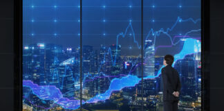 Getting More from Predictive Analytics with Holistic Technology businessman standing in front of visual screen displaying city with predictive analytics