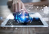 Choosing the Right CRM System in Today’s Digital-First World woman using a tablet with a crm holographic visual popping out of the tablet