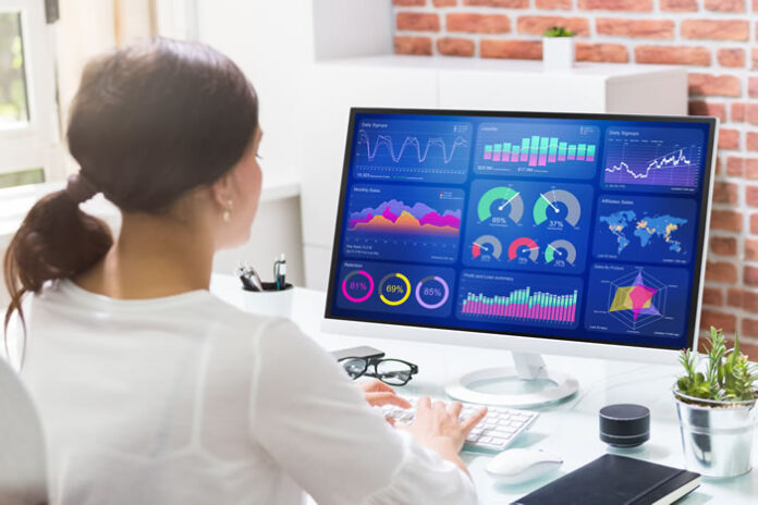 girl working at desk looking at cloud SaaS dashboards