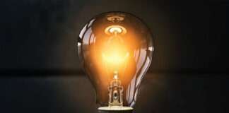 4 Affordable Ideas to Grow Your Business Without A Big Team picture of a yellowish light bulb lit up in a dark room