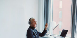young man smiling as he has a remote meeting on Zoom