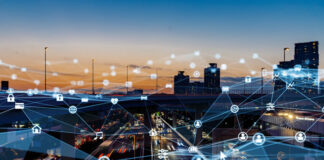 The Future is Edge Computing busy city skyline and freeway at dusk with digital IoT overlay pointing out all the wireless edge computing