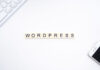 WordPress in Scrabble game letters on a desk with a keyboard and cell phone