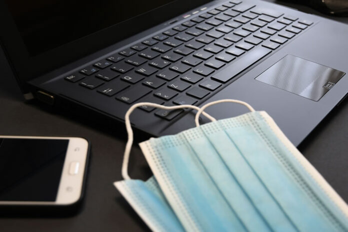 covid masks laying on a tech laptop keyboard