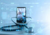 How Healthcare Can Embrace Digital Transformation mobile phone with healthcare provider on screen with a stethoscope connected to the phone