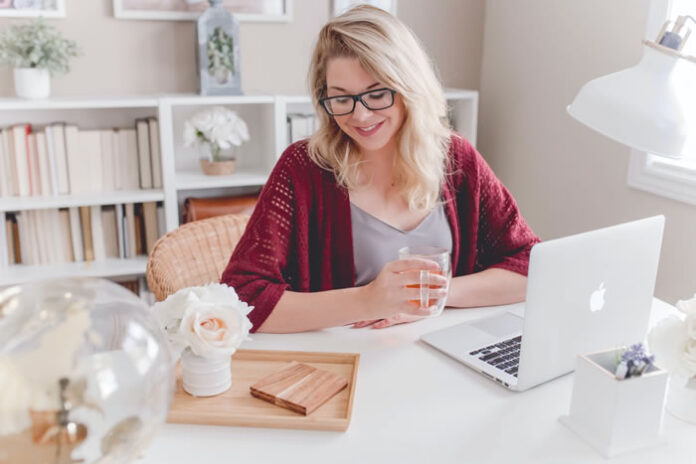 woman working from home on her laptop as her side hustle