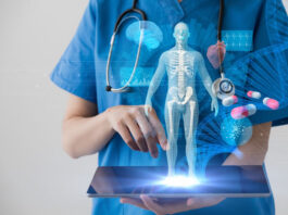 physician holding a tablet displaying a 3d image of human body