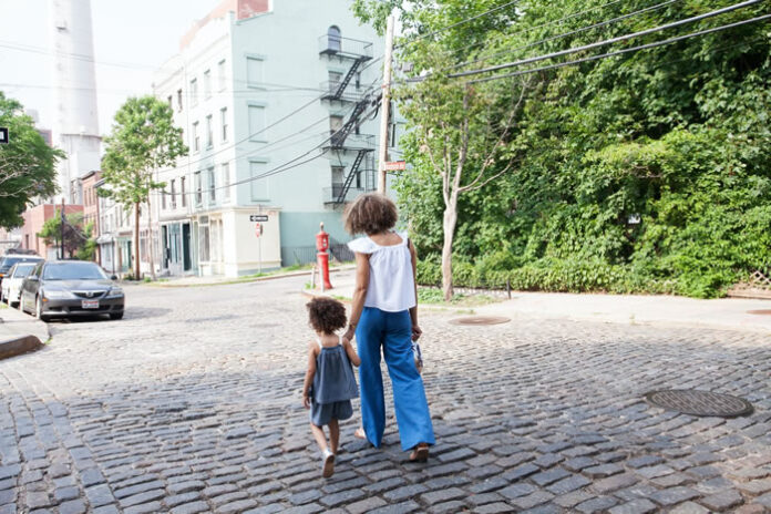 woman and toddler walking in their neighborhood