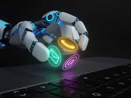 robot hand holding an electronic dice piece in front of keyboard