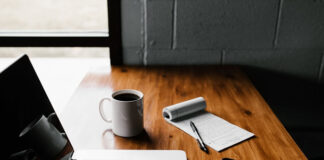 Tech Entrepreneurship 101 laptop coffee phone and notebook on desk