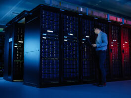 engineer inspecting rows of server cabinets in the cloud