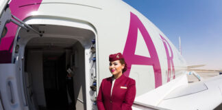 Seven Reasons Why Companies Should Invest in Company Uniforms stewardess in company uniform standing in front of airplane door