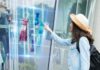 How Artificial Intelligence is Changing the Fashion Industry girl using virtual digital display to pick her fashion clothing