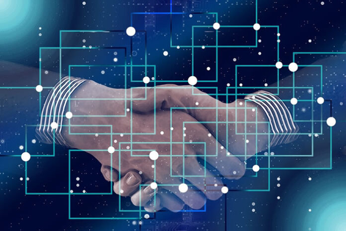 two businessmen handshake behind a digital data map
