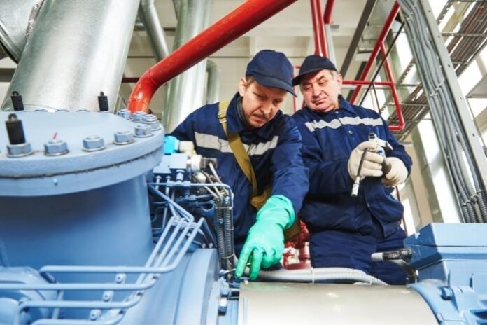 two men inspecting an industrial generator