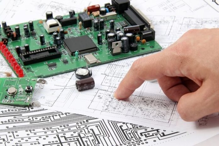man reviewing schematics of printed circuit board
