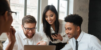 How to Create Better Experiences and Move Your Business Forward Faster smiling business team meeting over a laptop