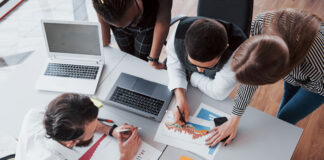 Optimal Digital Employee Experience (DEX) for the Future of Work group of employees analyzing digital work around a table