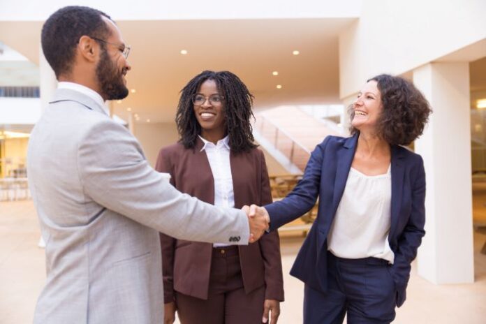 businessman shaking business woman's hand during merger deal
