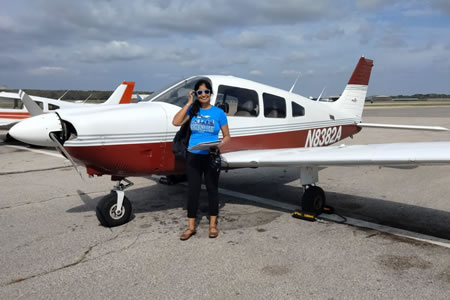 Nidhi Gupta standing in front of a small commuter airplane