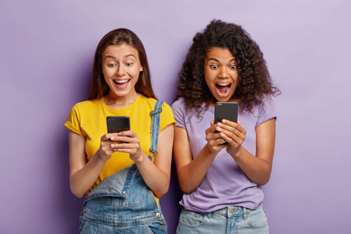 two girls excited while they are live shopping on their smartphones