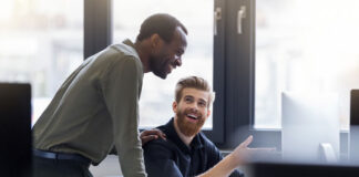 Managed Services Providers: 2022 M&A Trends for Sellers-Part 1 two men smiling as they look at M&A trends for managed services providers