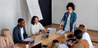 How to Address Business Diversity and Inclusion woman leading a discussion at a business diversity and inclusion meeting
