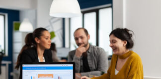 Following a Record 2021, M&A Still Strong for IT Businesses three business people talking about M&A still Strong for IT Businesses