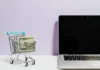7 Factors to Consider When Searching for a Shopping Cart Website! Shopping cart next to a laptop